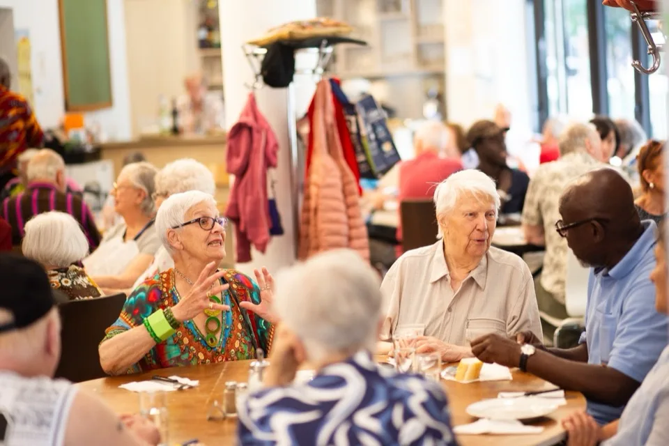 Bezoekers samen aan tafel in De Harmonie